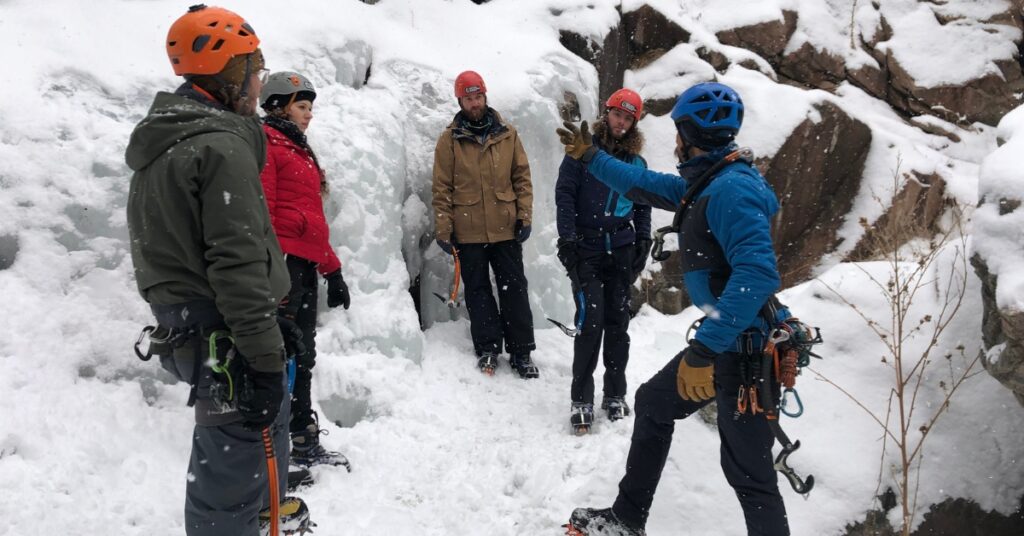 Introduction to ice climbing students learning how to swing an ice tool in Golden Colorado