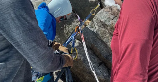Advanced mountaineering students setting up a rappel in Colorado