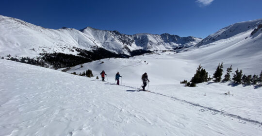 Avalanche education students ski touring through the backcountry in Colorado