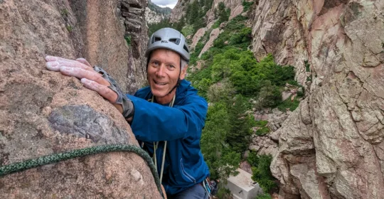 A rock climber high on the Bastille Crack in Boulder Colorado