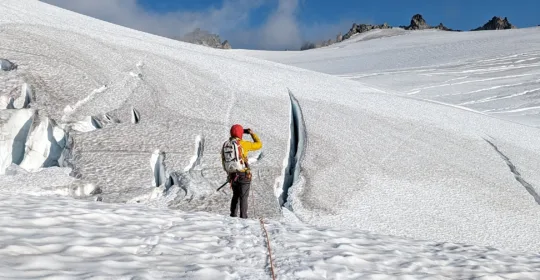 A crevasse rescue student looking at the glaciated terrain in Washington State