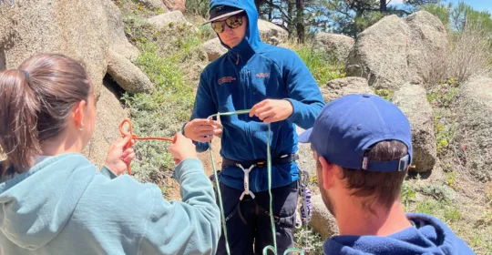 Introduction to trad climbing students reviewing knots in Boulder Colorado