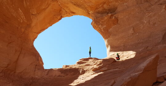 Rock climbers exploring Looking Glass Arch in Moab Utah