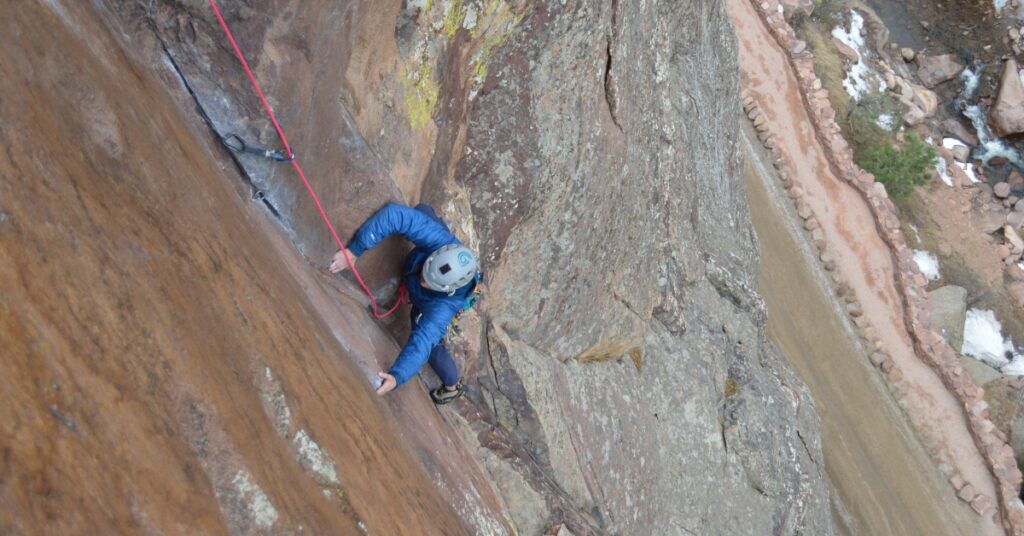 A rock climber on the dihedral pitch of Outer Space in Boulder Colorado