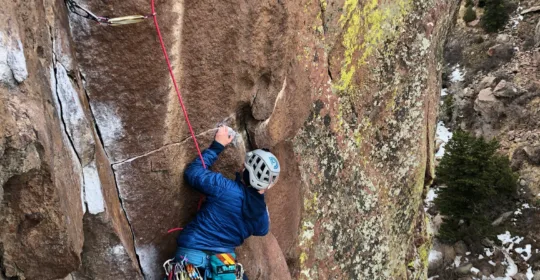 A rock climber on pitch three of the classic Outer Space in Boulder Colorado