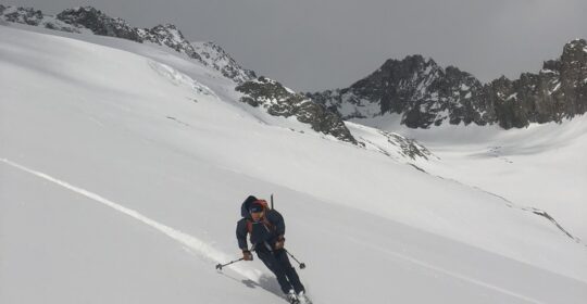 A backcountry skier skiing powder in Colorado