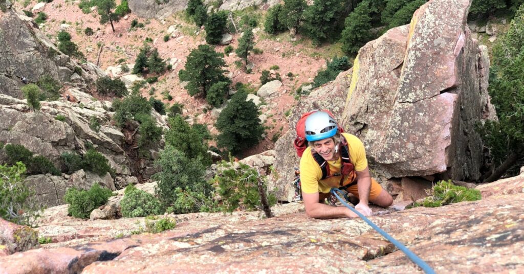 A rock climber topping out Rewritten in Eldorado Canyon State Park Colorado