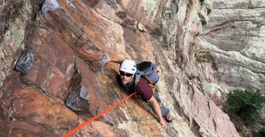 A climber on the crux pitch of Ruper in Eldorado Canyon State Park Colorado