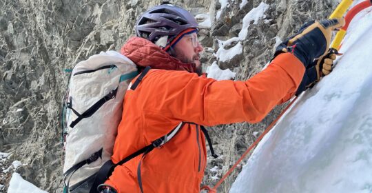 A student in the steep ice climbing course swinging an ice tool