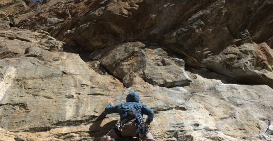 A rock climber leading in Clear Creek Canyon during the winter climbing months in Colorado
