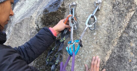 A rock climber learning how to clean and build anchors in Clear Creek Canyon Colorado