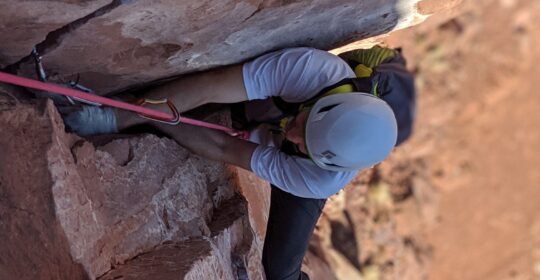 A rock climber being guided in Moab Utah
