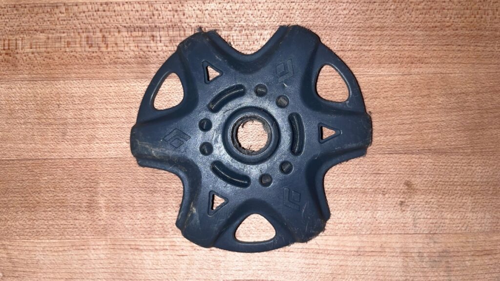 An extra powder basket in a backcountry ski repair kit