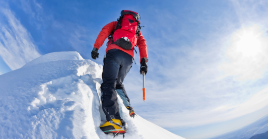 climber summiting a peak after training session